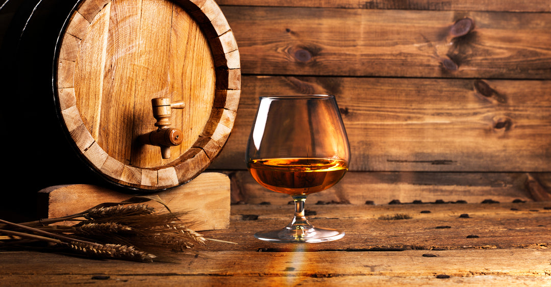 Brandy Glass in Front of an Oak Aging Barrel | Blind Pig Drinking Co.